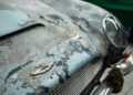 Close-up of the hood and grille of a rare DB5 with peeling paint, rust, and the Aston Martin emblem visible—each mark tells an incredible story of its journey from Aston Martin Works.