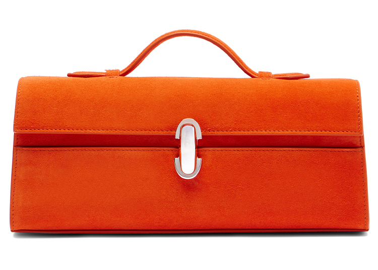 A rectangular orange suede handbag with a top handle and a silver clasp centered on the front, perfect for the duPont REGISTRY Holiday Gift Guide 2026.