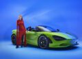 A woman in a red dress stands next to a green McLaren MSO 750S against a blue background, embodying the spirit of Project Chromology.