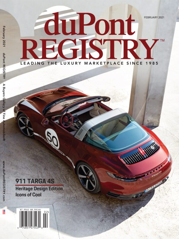 A red Porsche 911 Targa 4S Heritage Design Edition is parked under architectural arches, featured as one of the Cover Cars on the duPont REGISTRY magazine’s February 2021 issue, celebrating its 40th Anniversary.