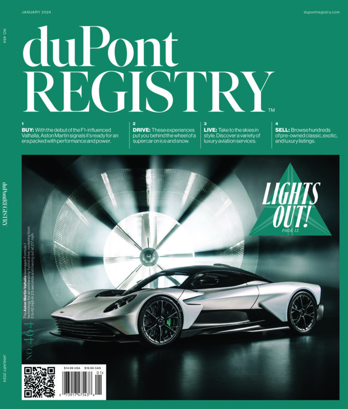 A sleek silver sports car is displayed in front of a large, illuminated turbine fan on the cover of duPont REGISTRY’s 40th Anniversary issue, celebrating iconic Cover Cars.