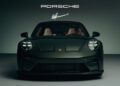 Front view of a dark green Porsche 911 GT3 with headlights on, displayed in a studio setting under Porsche and signature logos, celebrating the 90th Birthday of F. A. Porsche.